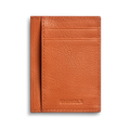 The Canfield ID Card Holder by Shinola is a slim, rust-colored pebbled leather wallet with two card slots and the brand's name embossed at the bottom, perfect for stylishly carrying your ID.