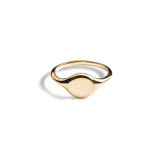 The Shinola Petite Round Signet Ring - Yellow Gold features a smooth, oval face in 14k gold, offering timeless elegance. Photographed on a white background.