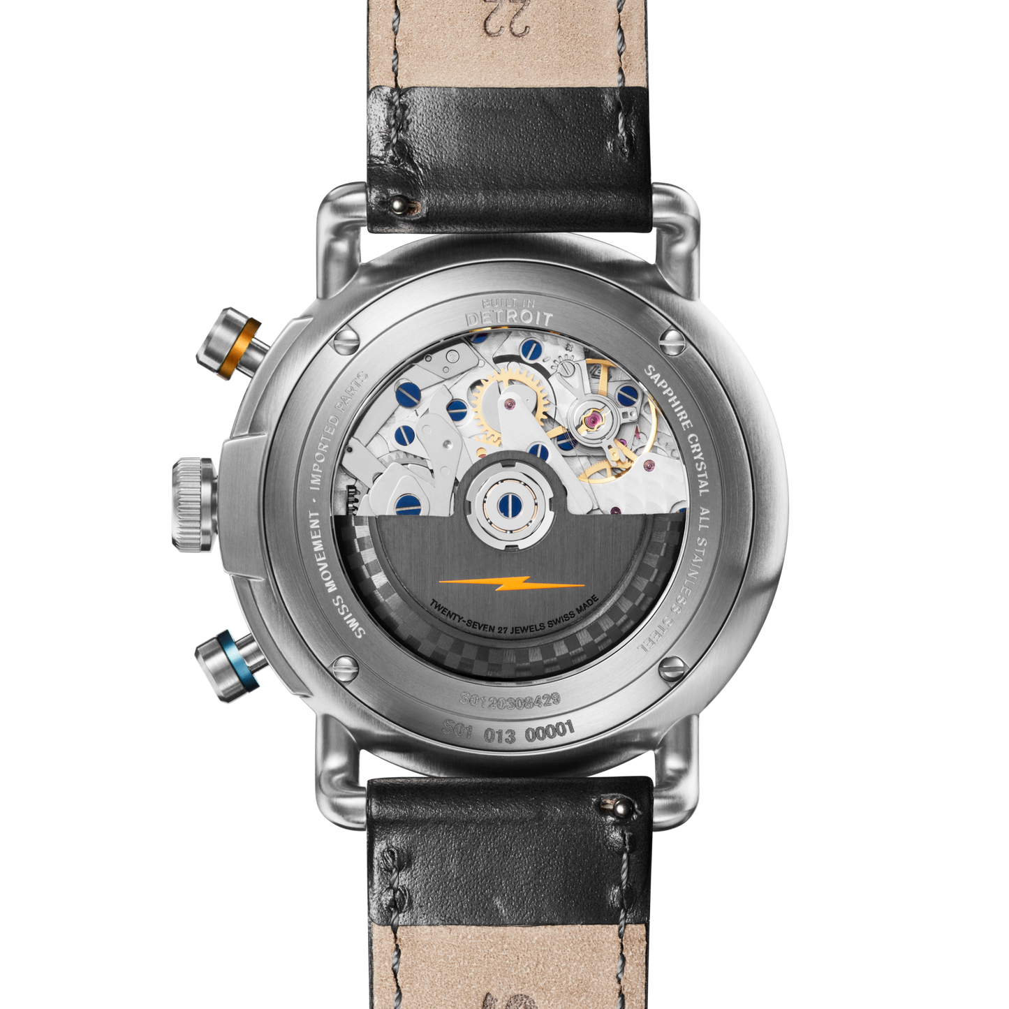 The image shows the back of the Shinola Canfield Speedway Open Road Automatic Chronograph Watch - Black, featuring a transparent case that reveals its Swiss-made movement, leather strap, visible screws, and silver, blue, and gold component details.