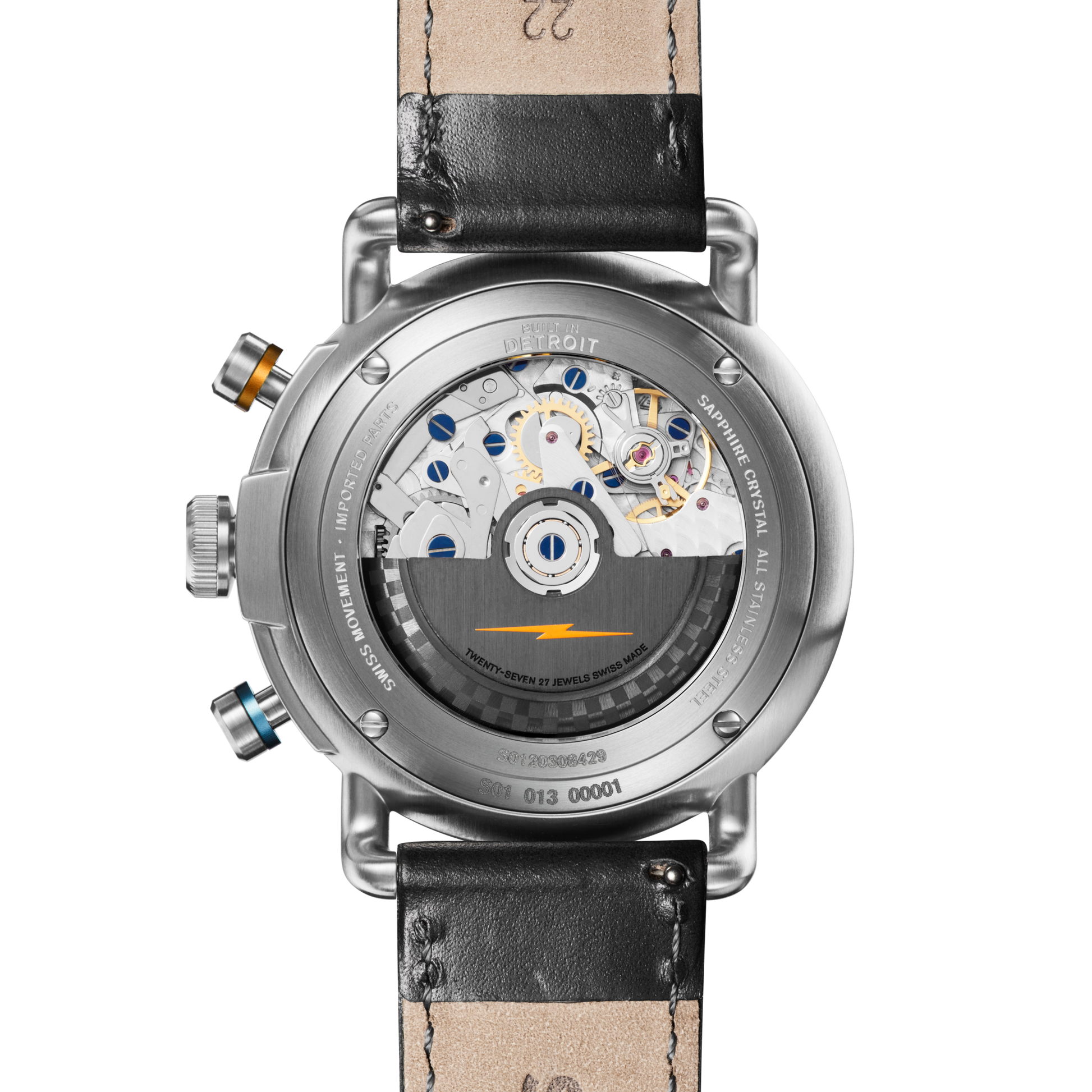 The image shows the back of the Shinola Canfield Speedway Open Road Automatic Chronograph Watch - Black, featuring a transparent case that reveals its Swiss-made movement, leather strap, visible screws, and silver, blue, and gold component details.
