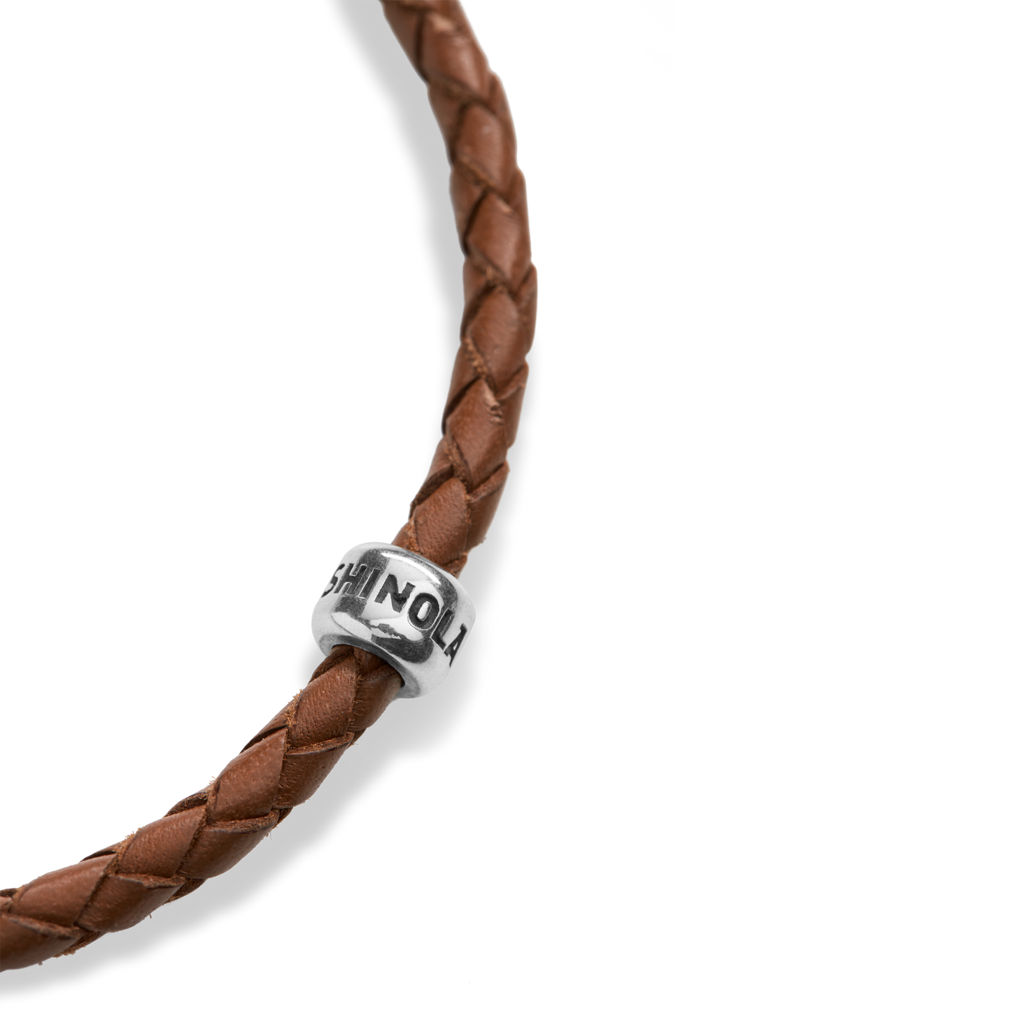Close-up of the Shinola Single Wrap Woven Leather Bracelet in tan, featuring a sterling silver clasp and a silver bead engraved with "SHINOLA," displayed on a plain white background.