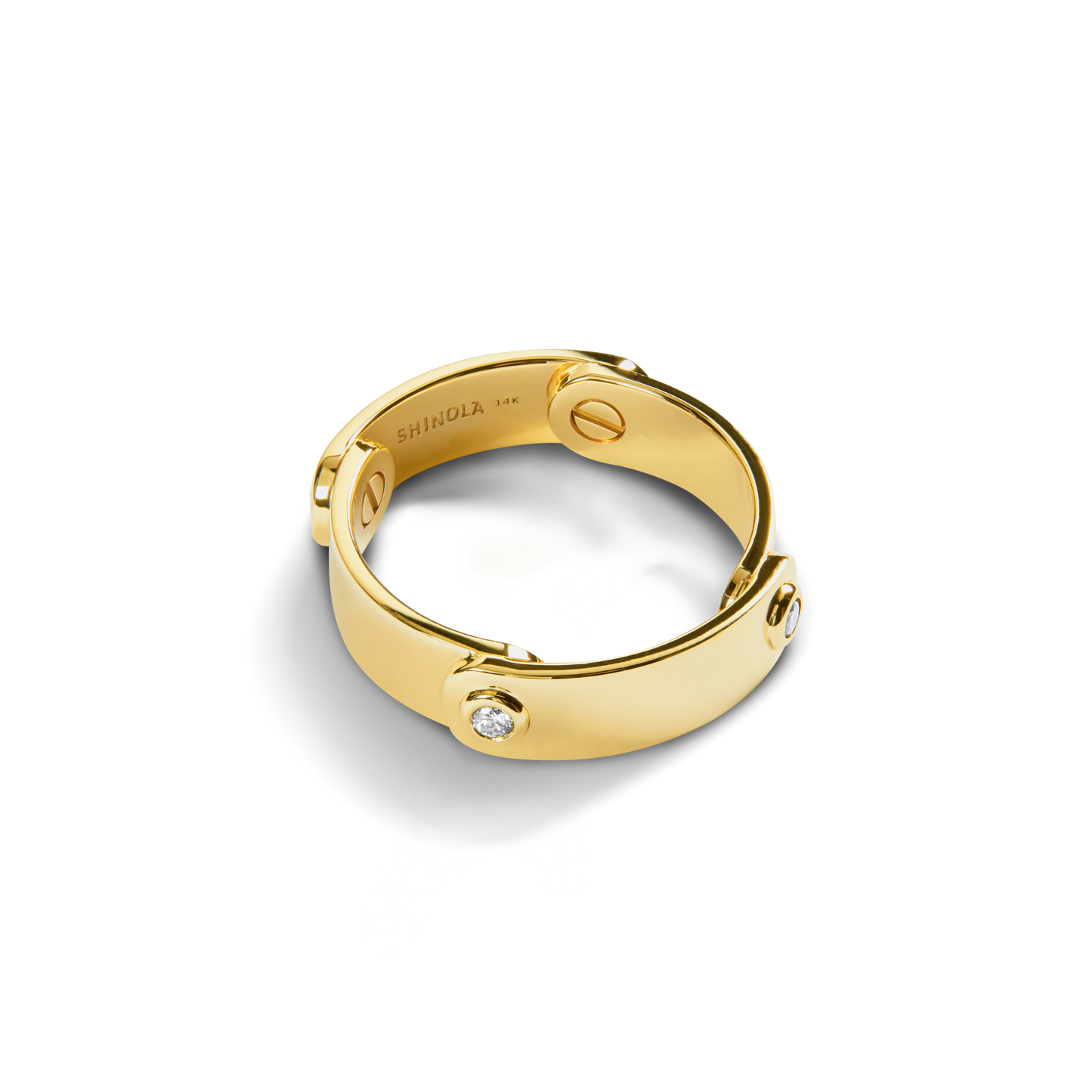 The Diamond Rivet Plaque Ring by Shinola features 14K yellow gold with three round, diamond-set rivet accents. The inner band is stamped SHINOLA 14K and the ring is displayed on a white background.