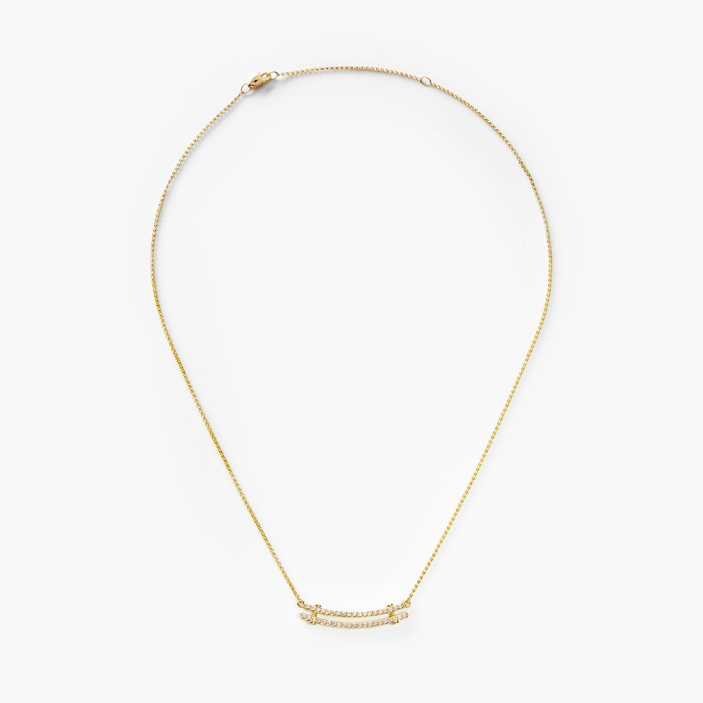 The Shinola Diamond Pave Rivet Double Row Necklace in yellow gold features two curved, crystal-encrusted bars on a fine double chain, elegantly displayed against a white background.