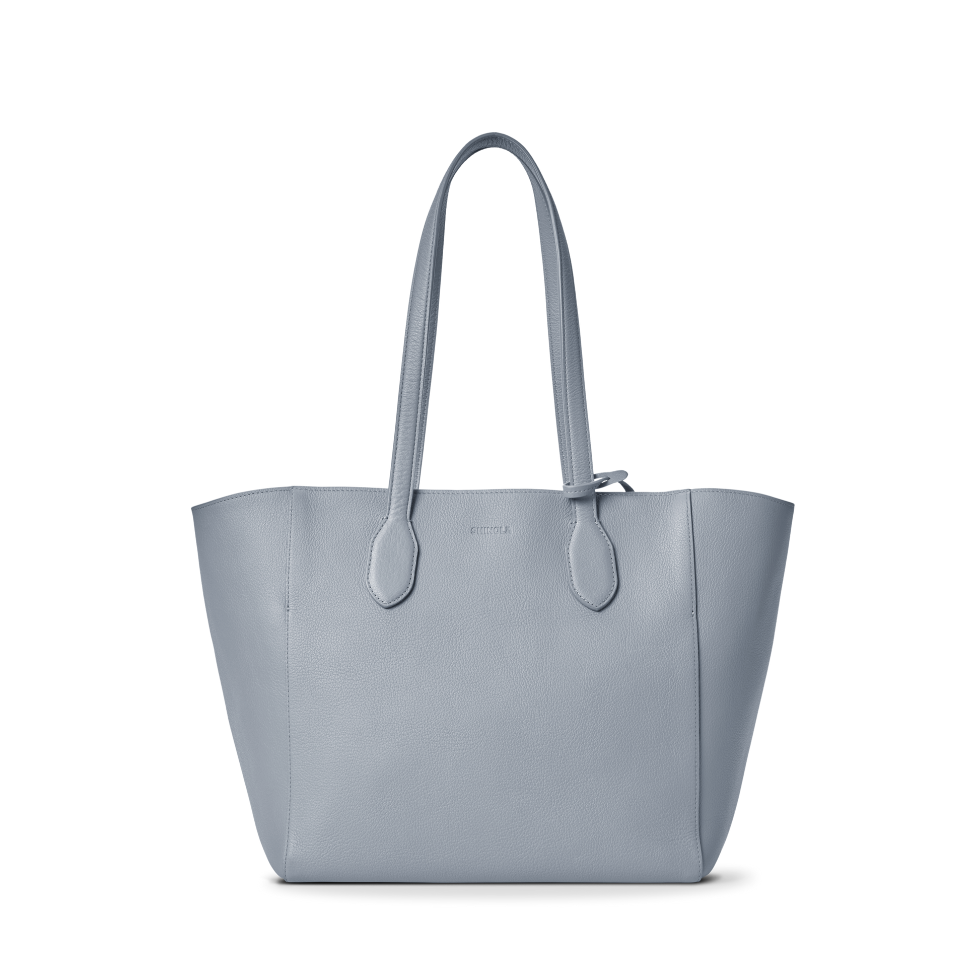 The Shinola Runabout Tote Bag - Mist features light blue pebbled leather, two shoulder straps, a structured design, subtle stitching, and an interior zipper pouch, shown against a plain white background.