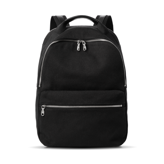 The Shinola Runwell Canvas Backpack in black features two front zippered compartments, adjustable shoulder straps, and a top handle for durability and everyday use, displayed against a plain white background.