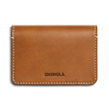 The Shinola Business Card Holder - Tan is crafted from Italian Vachetta leather with white stitching, featuring SHINOLA embossed on the front. Personalize it with monogramming for a unique touch.