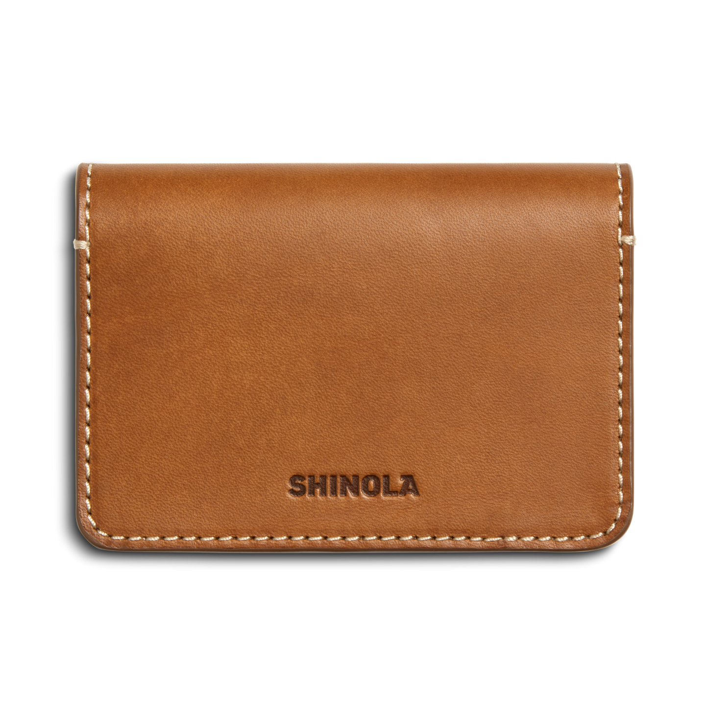 The Shinola Business Card Holder - Tan is crafted from Italian Vachetta leather with white stitching, featuring SHINOLA embossed on the front. Personalize it with monogramming for a unique touch.