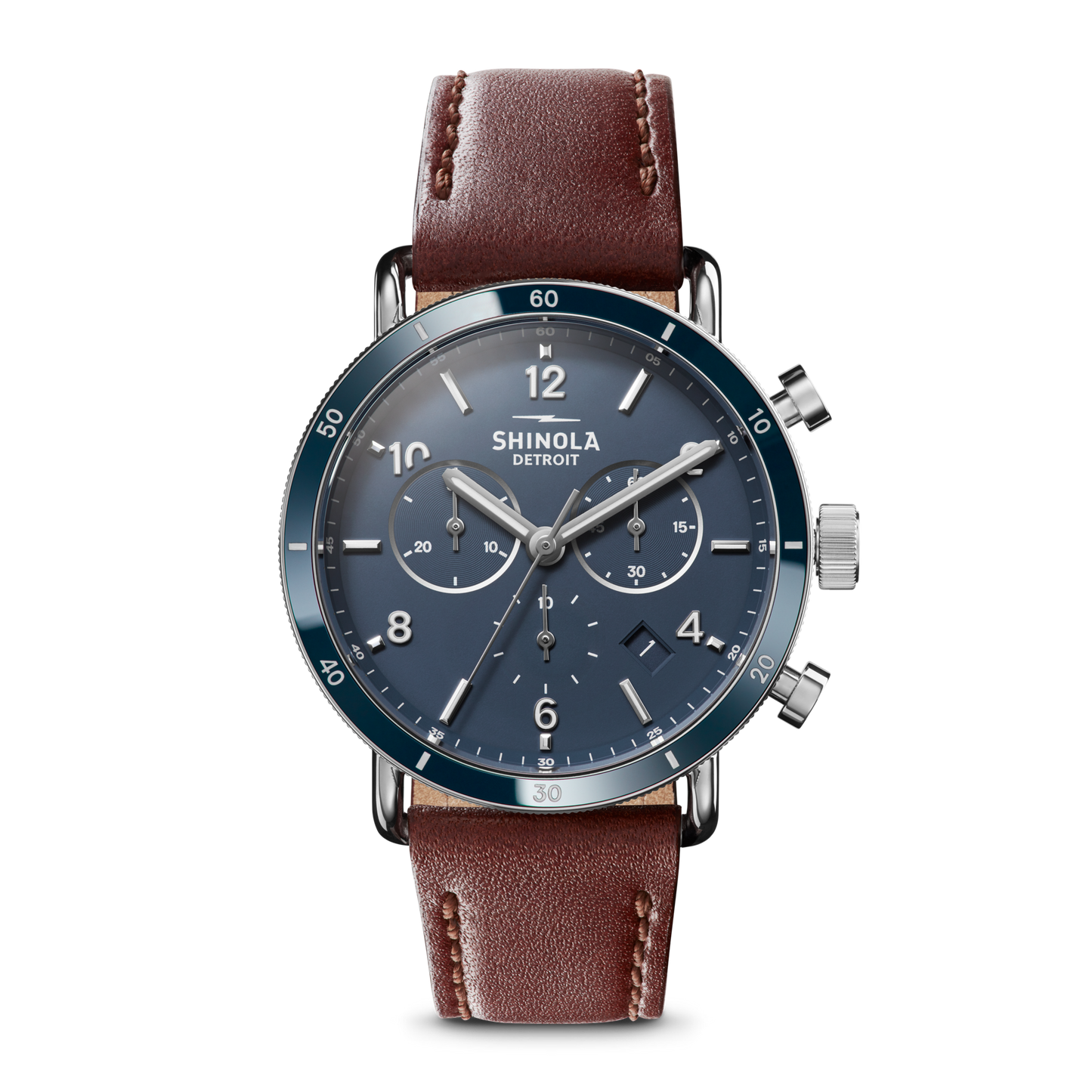 The Shinola Canfield Sport Chronograph Watch - Midnight Blue features a blue dial with silver hands and markings, three subdials, a chronograph function, and a brown leather strap. The watch face reads Shinola Detroit on a plain white background.