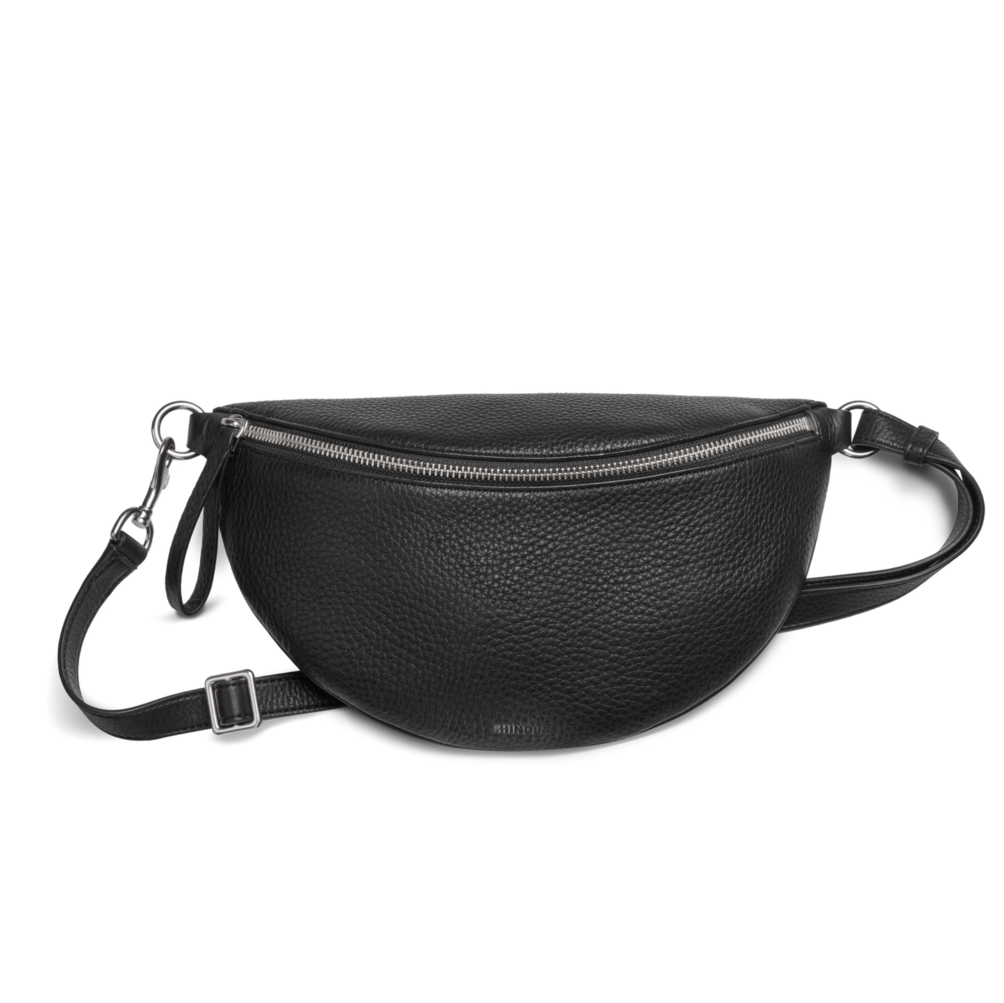 The Shinola Sling Bag - Black features textured leather in a half-moon shape, a zipper closure, adjustable leather strap, and silver hardware, displayed against a plain white background.