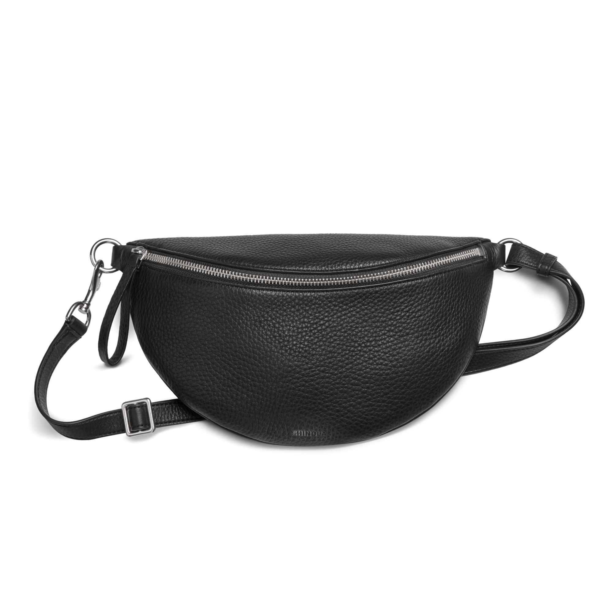 The Shinola Sling Bag - Black features textured leather in a half-moon shape, a zipper closure, adjustable leather strap, and silver hardware, displayed against a plain white background.