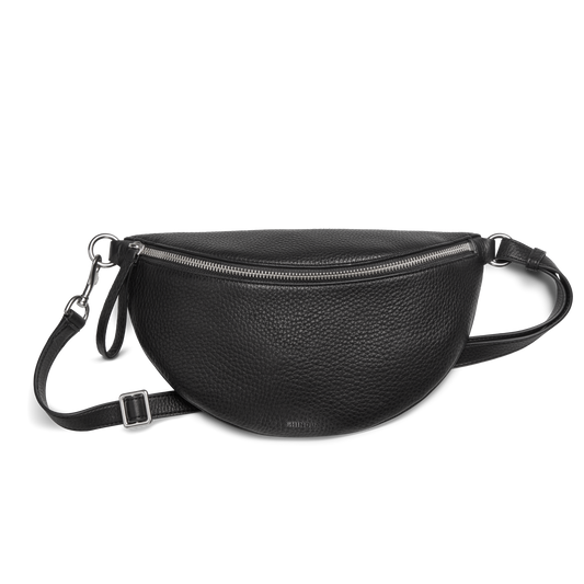 The Shinola Sling Bag - Black features textured leather in a half-moon shape, a zipper closure, adjustable leather strap, and silver hardware, displayed against a plain white background.