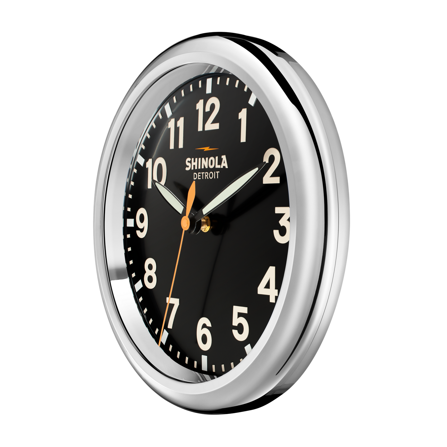The 14" Runwell Clock by Shinola features a round black face, shiny chrome casing, white numerals, and three hands. "Shinola Detroit" is displayed on the dial, with the time set to around 1:09:31.