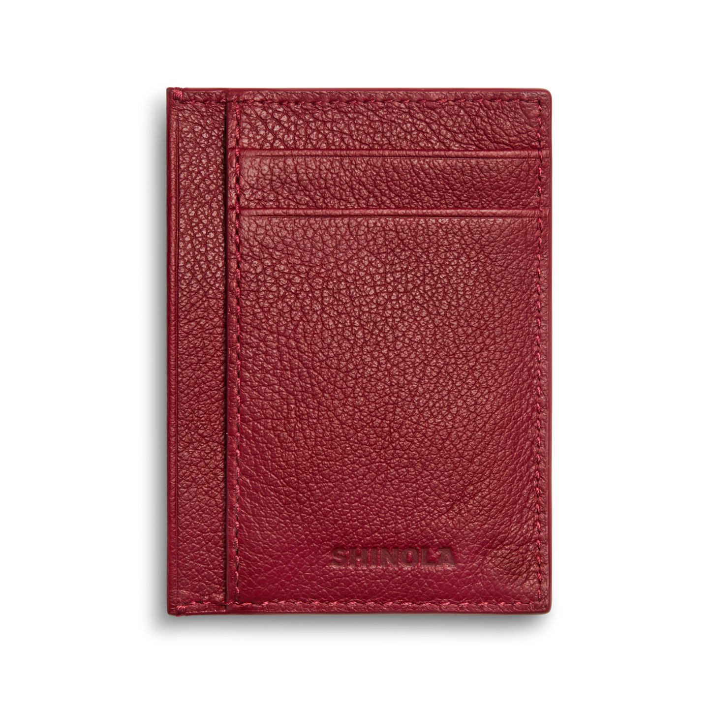 The Shinola Canfield ID Card Holder in Ruby features a burgundy pebbled leather design, two card slots, and subtle embossed branding at the bottom right, set against a plain white background.