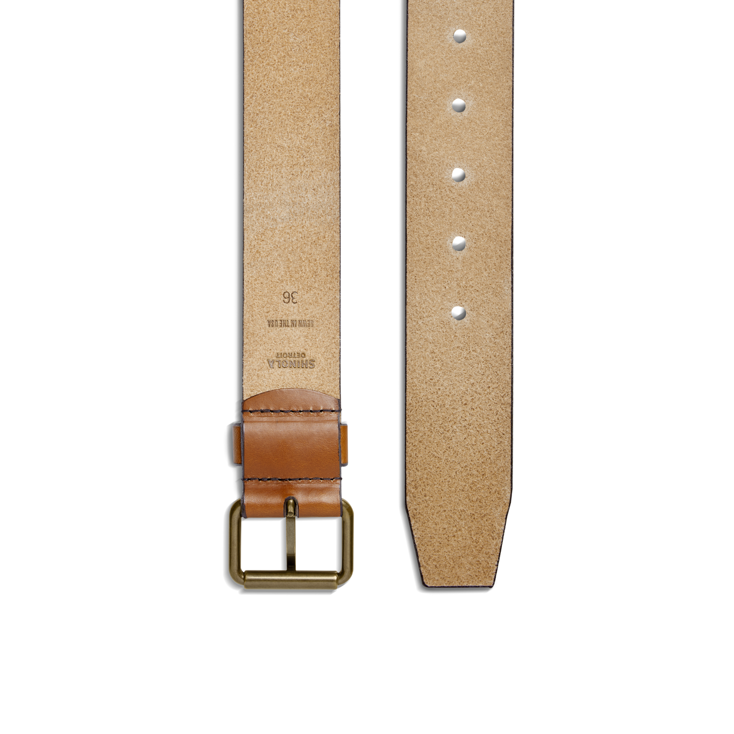 The Shinola 1 1/2" Rambler Belt in tan is handcrafted from bridle leather with a brass buckle. It features punched holes, stamped text and numbers inside near the buckle—an ideal everyday accessory. Shown from the back.