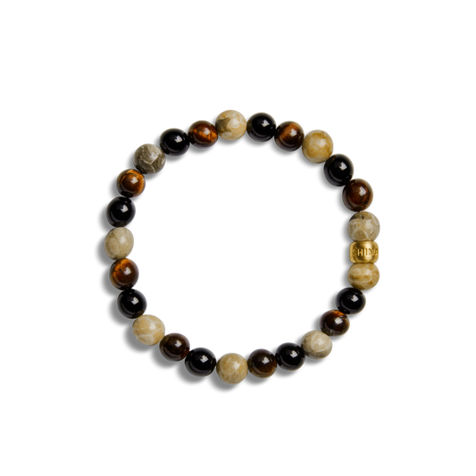 The Shinola 8mm Beaded Bracelet Multi Stone features alternating brown, black, and beige round stones with a gold cylindrical bead, all arranged in a circular pattern on a plain white background.