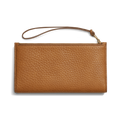 The Shinola Wristlet Wallet - Tan is crafted from natural grain leather and features card pockets, a zipper closure, and a slim wrist strap, displayed against a white background.