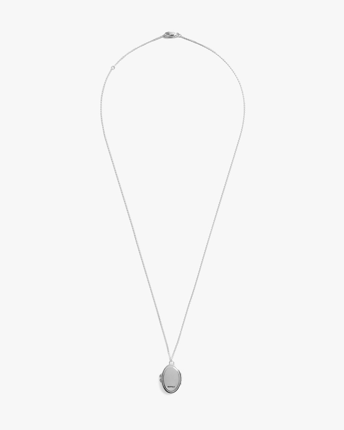 The Shinola Heirloom Statement Locket Necklace, crafted in sterling silver with an oval pendant, is displayed against a plain white background.