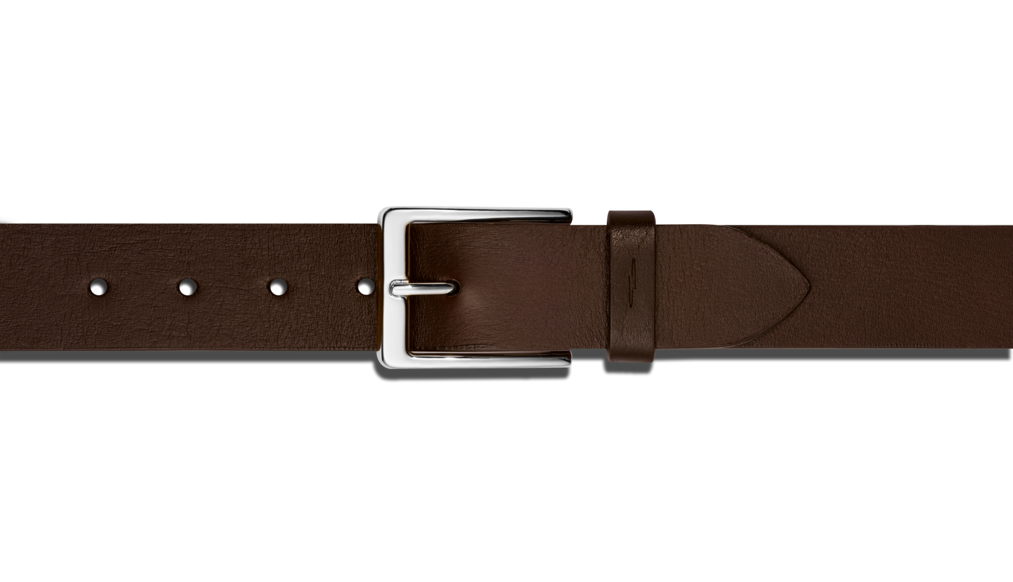 A close-up of the Shinola 1 1/2" Lightning Bolt Keeper Belt in deep brown leather, featuring a shiny silver-tone rectangular buckle and hardware, displayed on a plain white background.