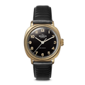 The Shinola Mechanic Watch - Black/Gold features a gold case, black dial, black leather strap, and an exhibition case back.