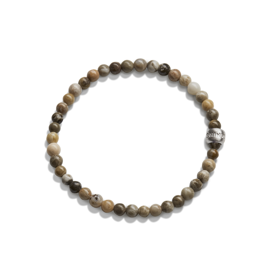 The Shinola 4mm Beaded Petoskey Bracelet features small, round Petoskey stones in brown, beige, and gray with a single engraved sterling silver accent bead.