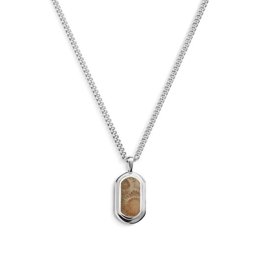 The Shinola Petoskey Tag Necklace in sterling silver features a rectangular pendant with a light brown, fingerprint-like pattern, inspired by unique gemstone jewelry. The shiny silver frame contrasts beautifully against a plain white background.
