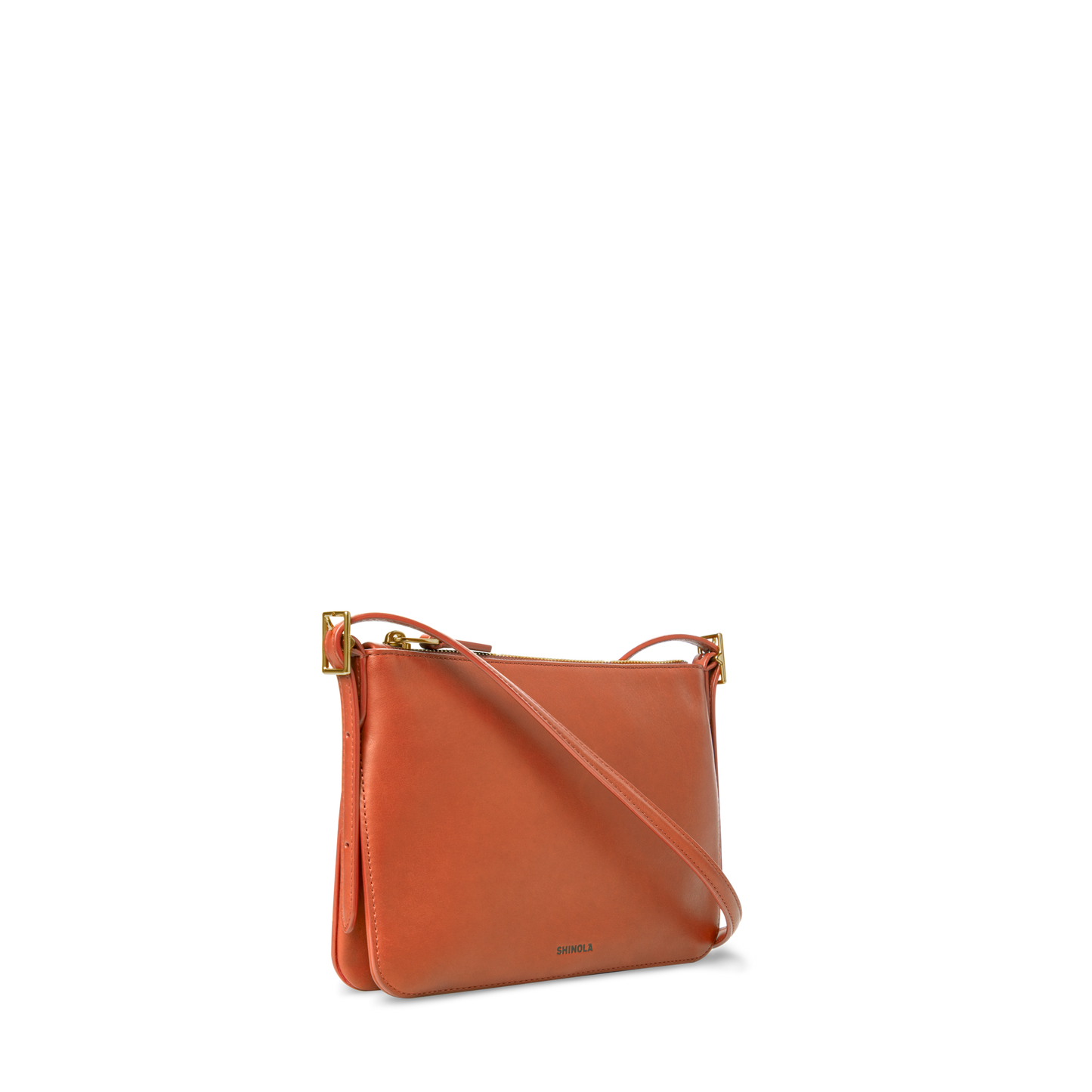 The Small Bixby Crossbody - Rust by Shinola is a compact, rectangular orange leather bag with gold hardware and an adjustable strap, shown on a plain white background.