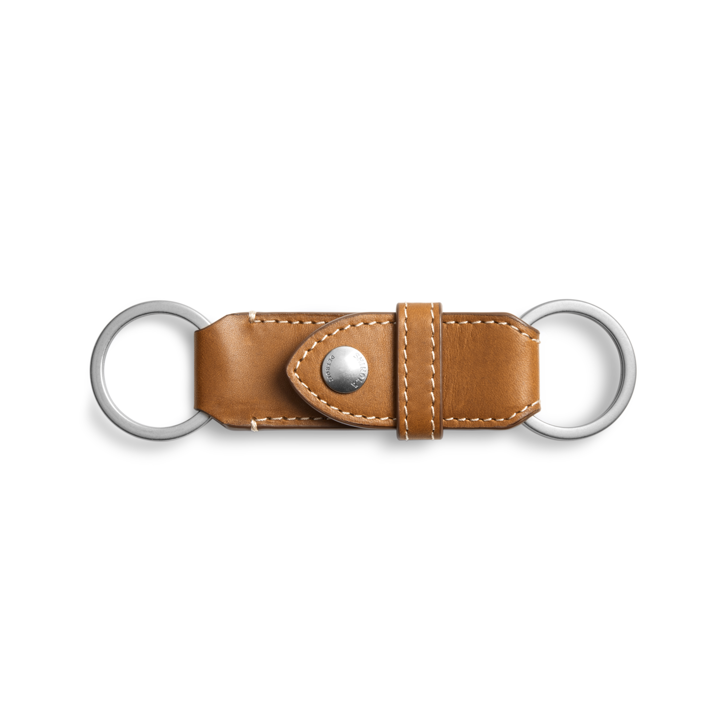 The Shinola Leather Valet Key Fob in tan features two silver rings, white stitching, and a buttoned center strap. This leather keychain is shown on a plain white background.