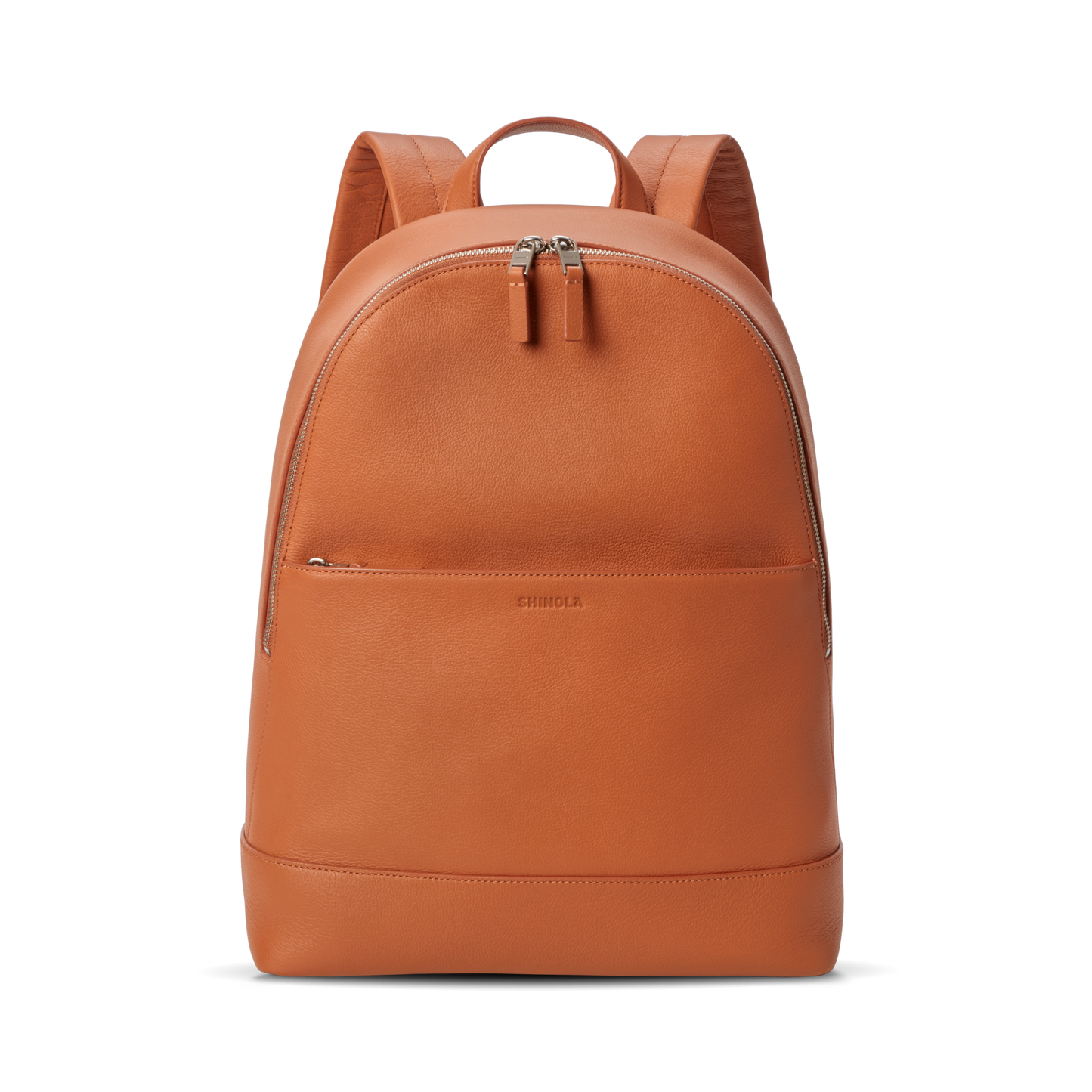 The Shinola Canfield Backpack in Rust is a sleek orange leather bag with a front zip pocket, dual zipper pulls on the main compartment, and padded shoulder straps—perfect for stylish travel—shown against a plain white background.