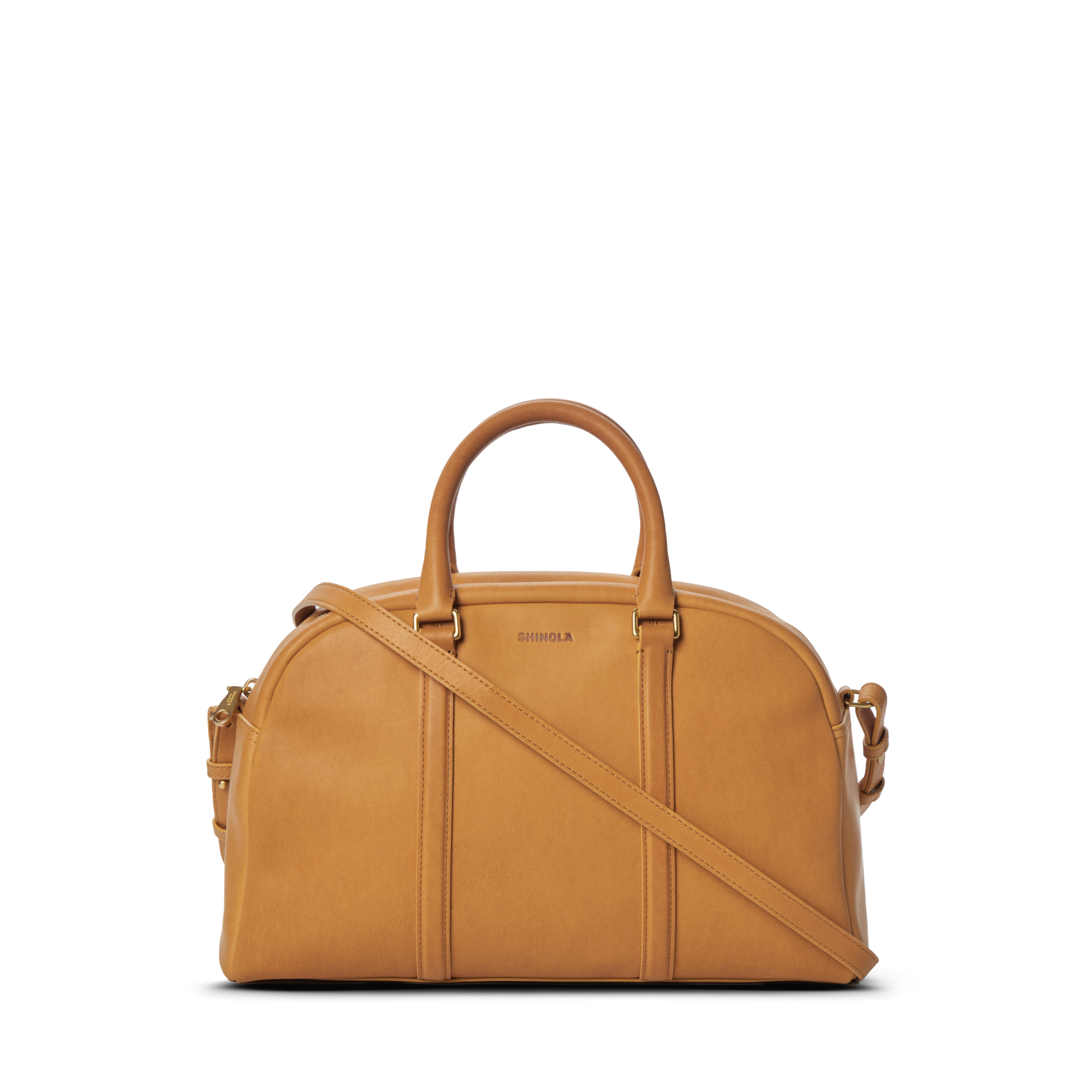 The Shinola Runwell Satchel - Honey is a premium natural leather handbag with two handles, a detachable shoulder strap, subtle vertical stitching, and a small embossed logo on its structured, rounded front.