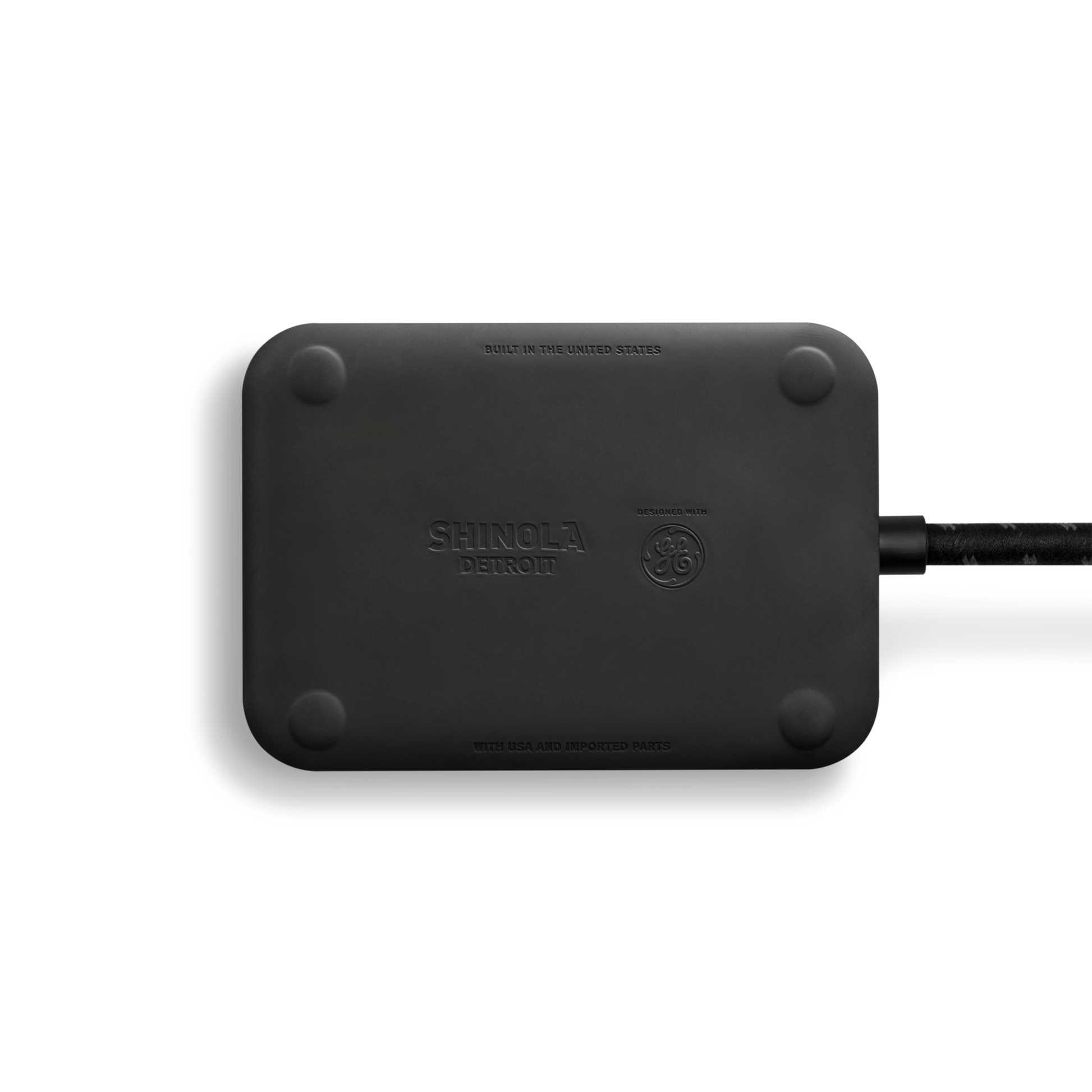 The Shinola 5 Port Power Supply - Black is a rectangular device with rounded corners, featuring a custom braided extension cord on the right side, bearing the Shinola logo, set against a white background.