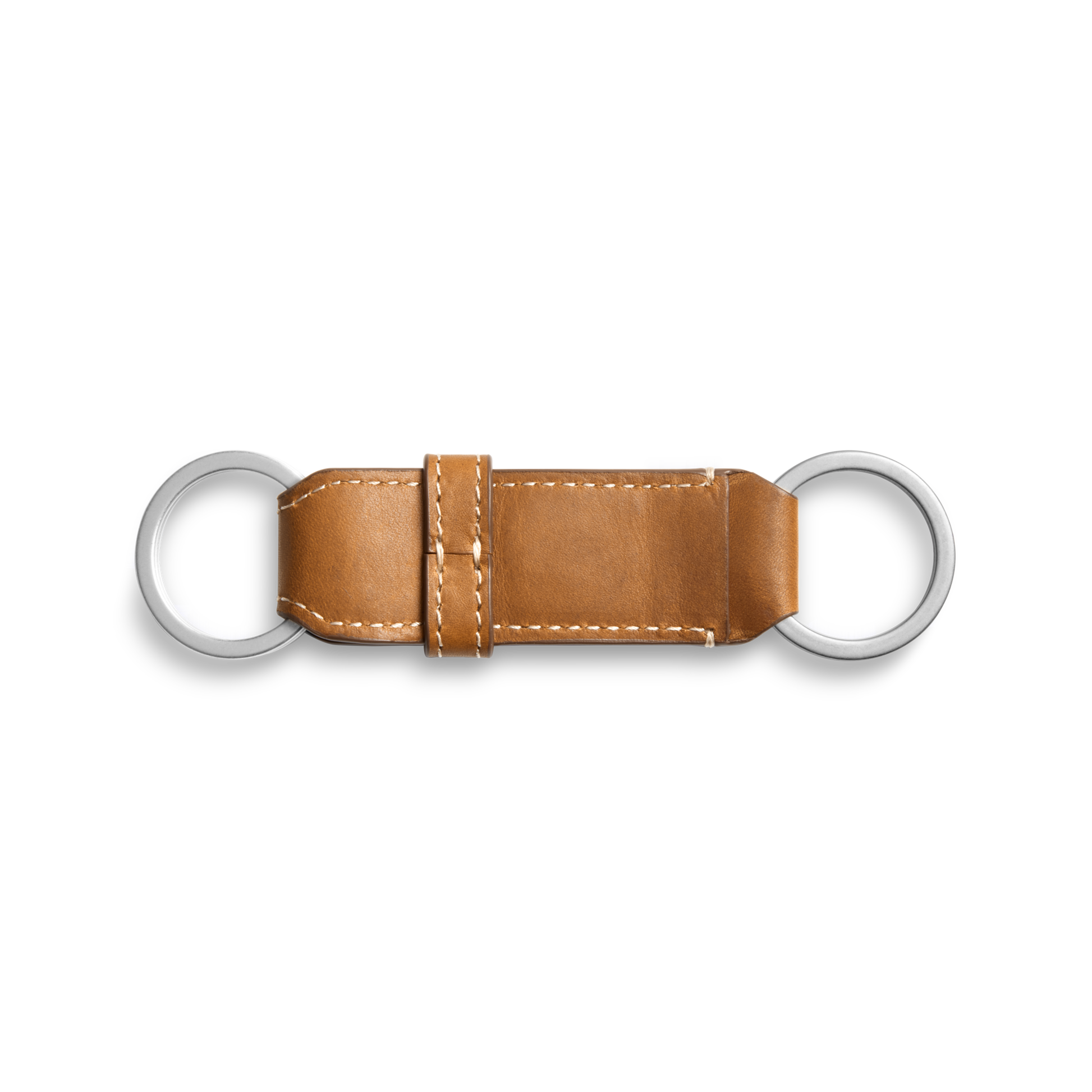 The Shinola Leather Valet Key Fob in tan features white stitching and two silver rings at each end, shown on a plain white background.