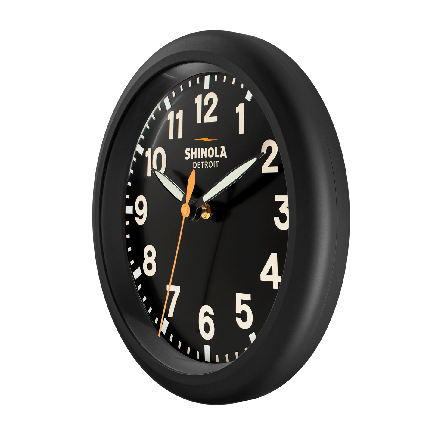The Shinola 14" Runwell Clock in black features a matte black dial with white numerals and hands, an orange second hand, and a black rim, shown at an angle against a white background.