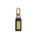 The Birdy Keychain - Black by Shinola is a natural leather key fob with a rectangular gold engravable plate engraved "TNML," attached to a brass clasp and ring, shown on a plain white background.