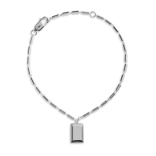 The Shinola Petite Rectangular Tag Chain Bracelet features sterling silver rectangular links and an engravable pendant, shown on a white background.