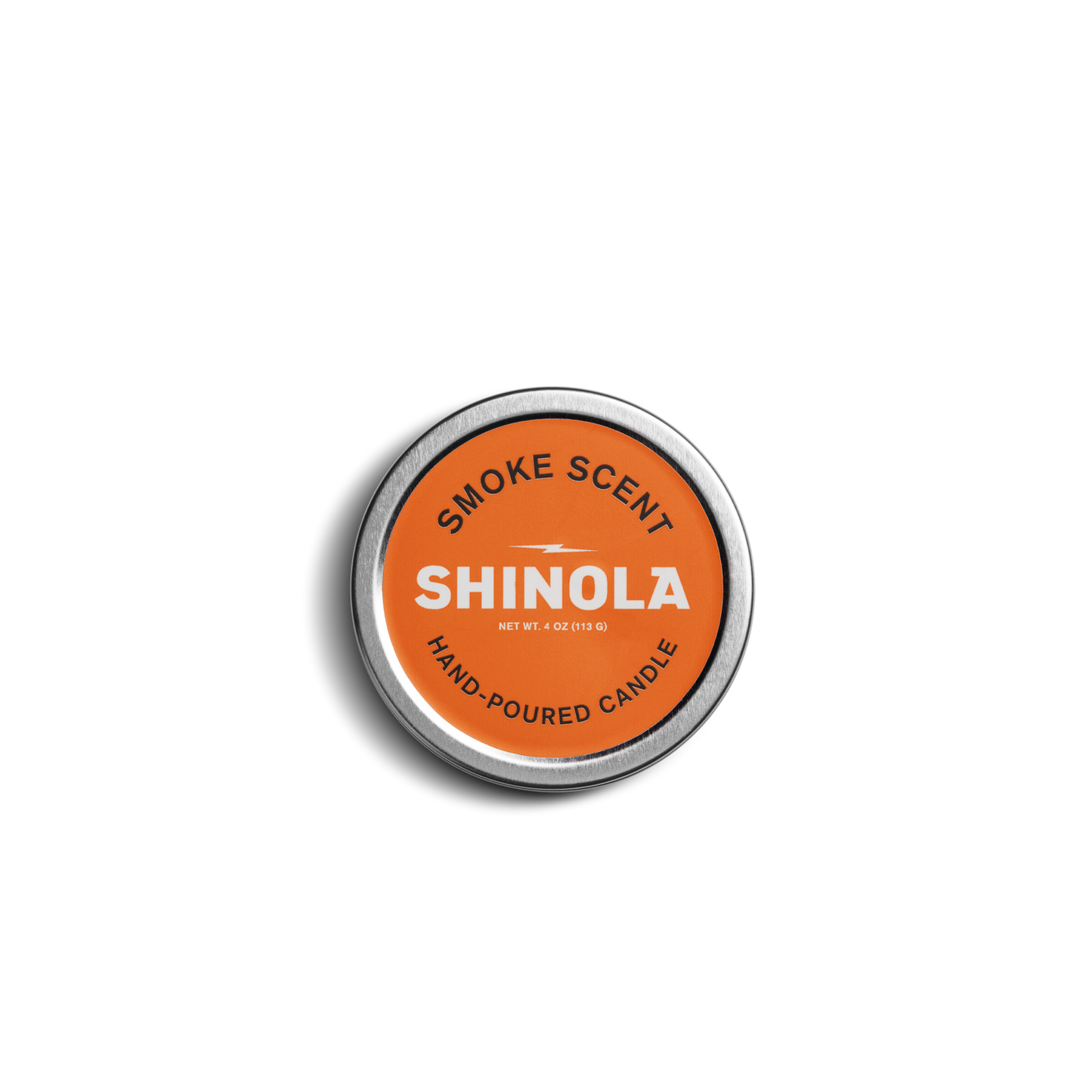 A 4oz Hand Poured Travel Candle by Shinola in the Smoke scent, featuring a round tin with an orange label, is shown against a white background.