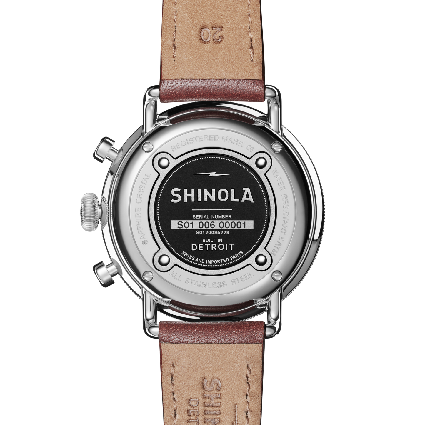 The back of a Shinola Canfield 2 Eye Chrono - Black wristwatch with a brown leather strap displays the serial number, “Built in Detroit,” and sapphire crystal details engraved around the stainless steel case.