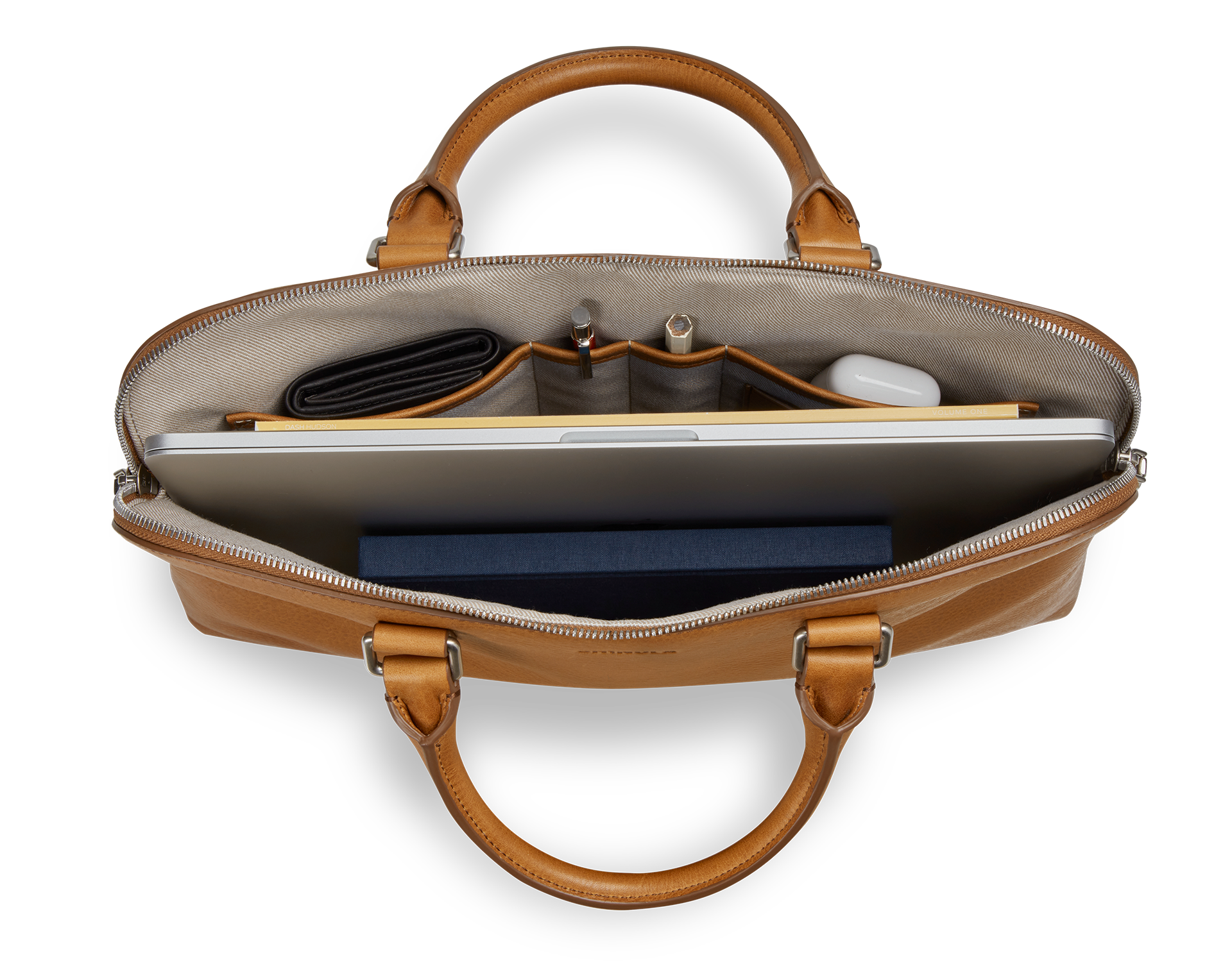 Top view of the Shinola Portfolio Briefcase - Tan, showcasing a laptop, wallet, pens, notebook, and wireless earbuds neatly organized in its compartments.