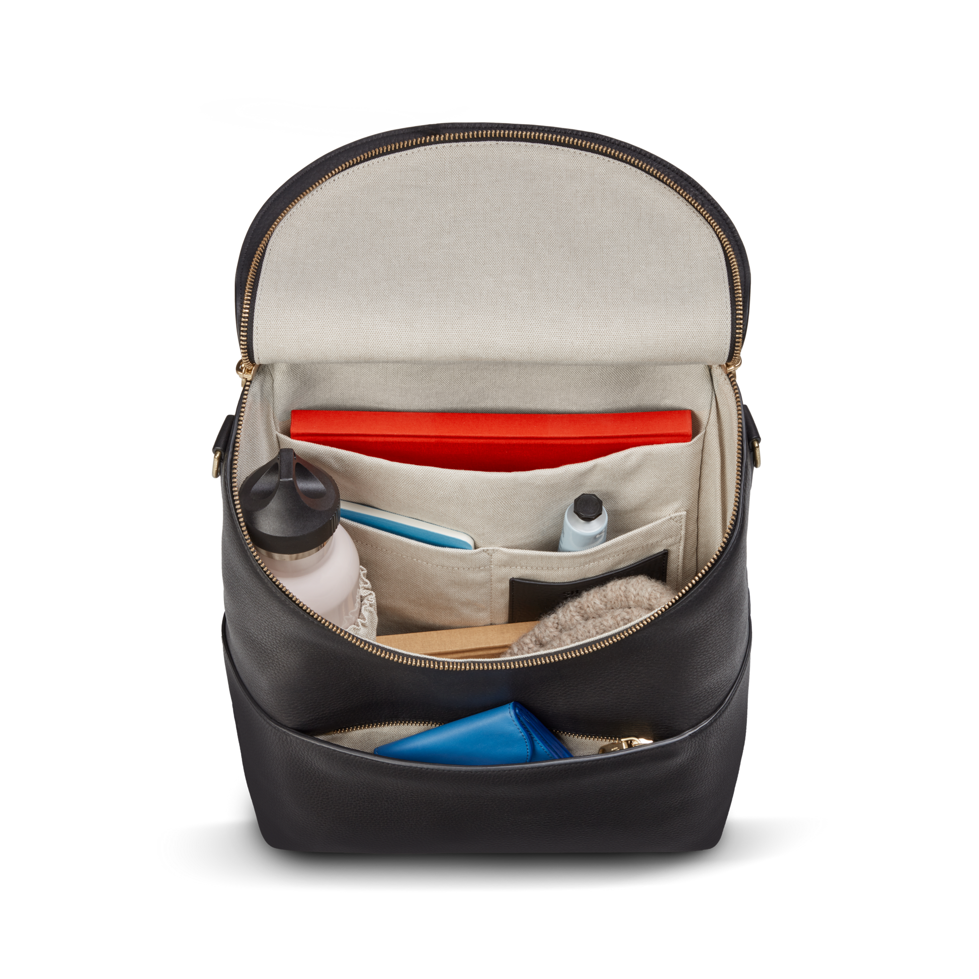 The Shinola Convertible Pocket Backpack - Brand Stripe / Black is shown open, revealing its organized beige-lined interior with a red tablet, water bottle, cables, blue pouch, and small items in pockets. Features zippered closure for hands-free everyday use.