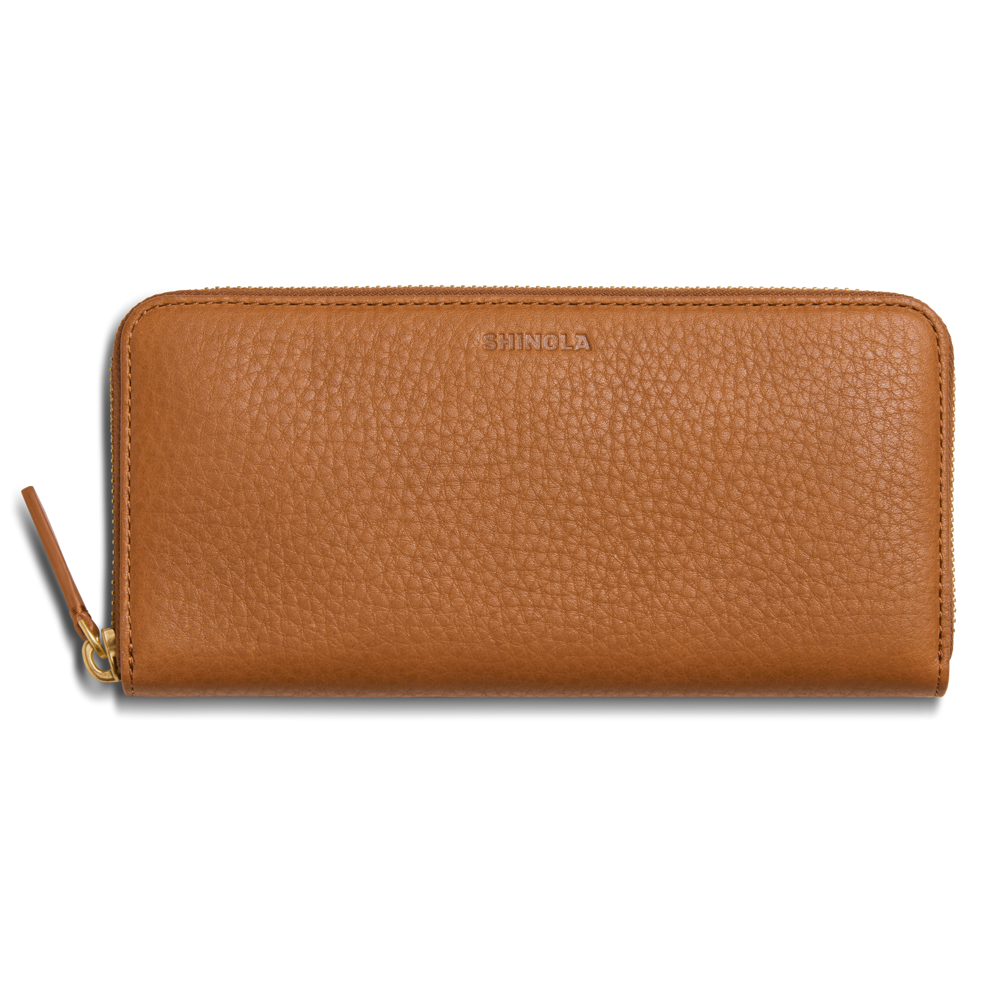 The Shinola Continental Zip Wallet - Tan is crafted from natural grain leather with a textured finish, features embossed branding at the top center, multiple interior card pockets, and a zipper with a matching leather pull tab.