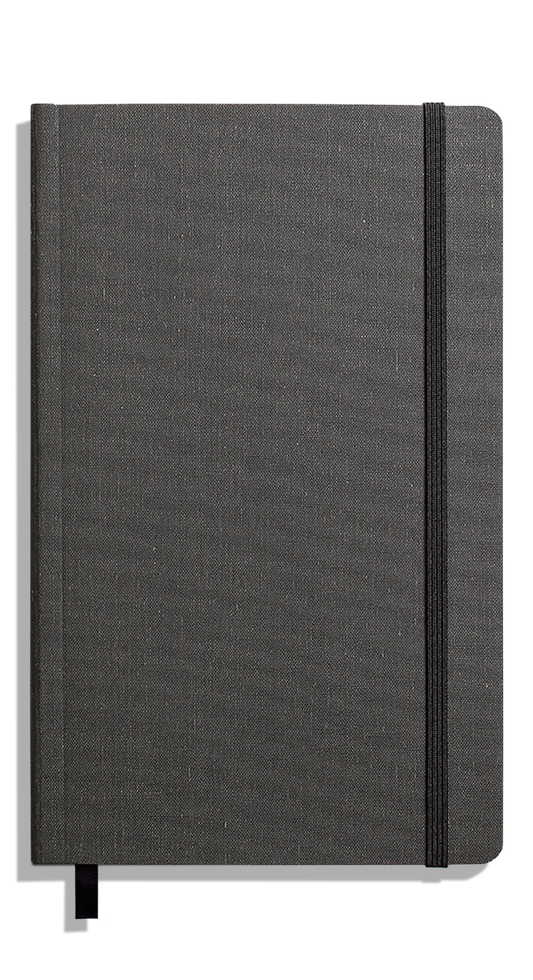 The Shinola Medium Soft Ruled Journal in charcoal, featuring a fabric-textured gray hardcover, elastic right-edge closure, and black ribbon bookmark, rests on a plain white background.