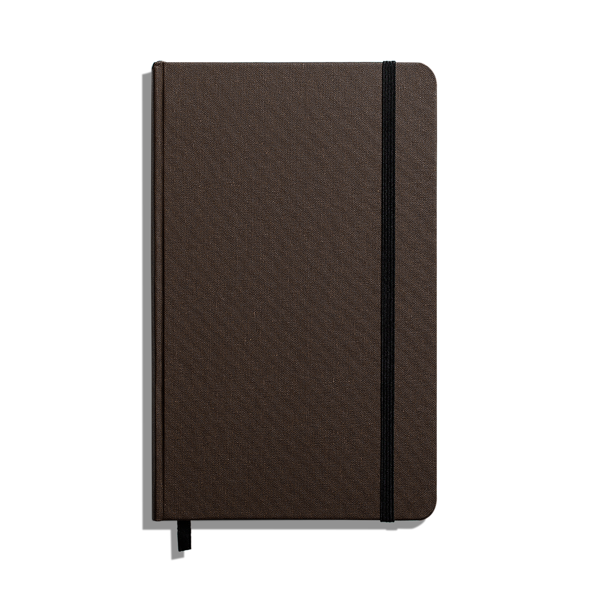 The Shinola Medium Hard Ruled Journal (5.25" x 8.25") is a closed brown hardcover notebook with rounded corners, a black elastic band, acid-free paper, and a black ribbon bookmark, displayed on a white background.