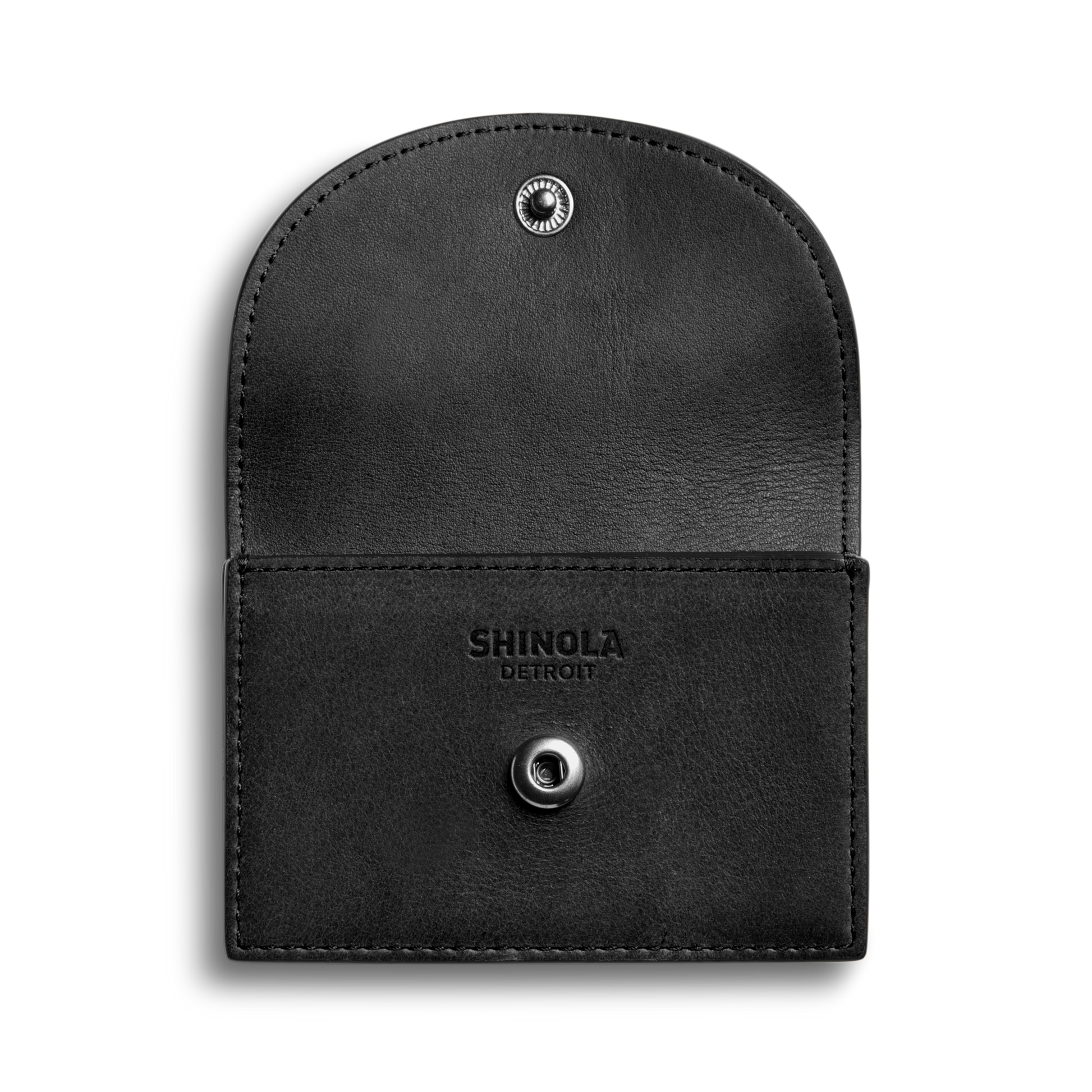 The Shinola Birdy Accordion Card Holder in black natural leather features an envelope design with a snap button closure, open to reveal card pockets and "Shinola Detroit" embossed on the inner flap, set against a plain white background.