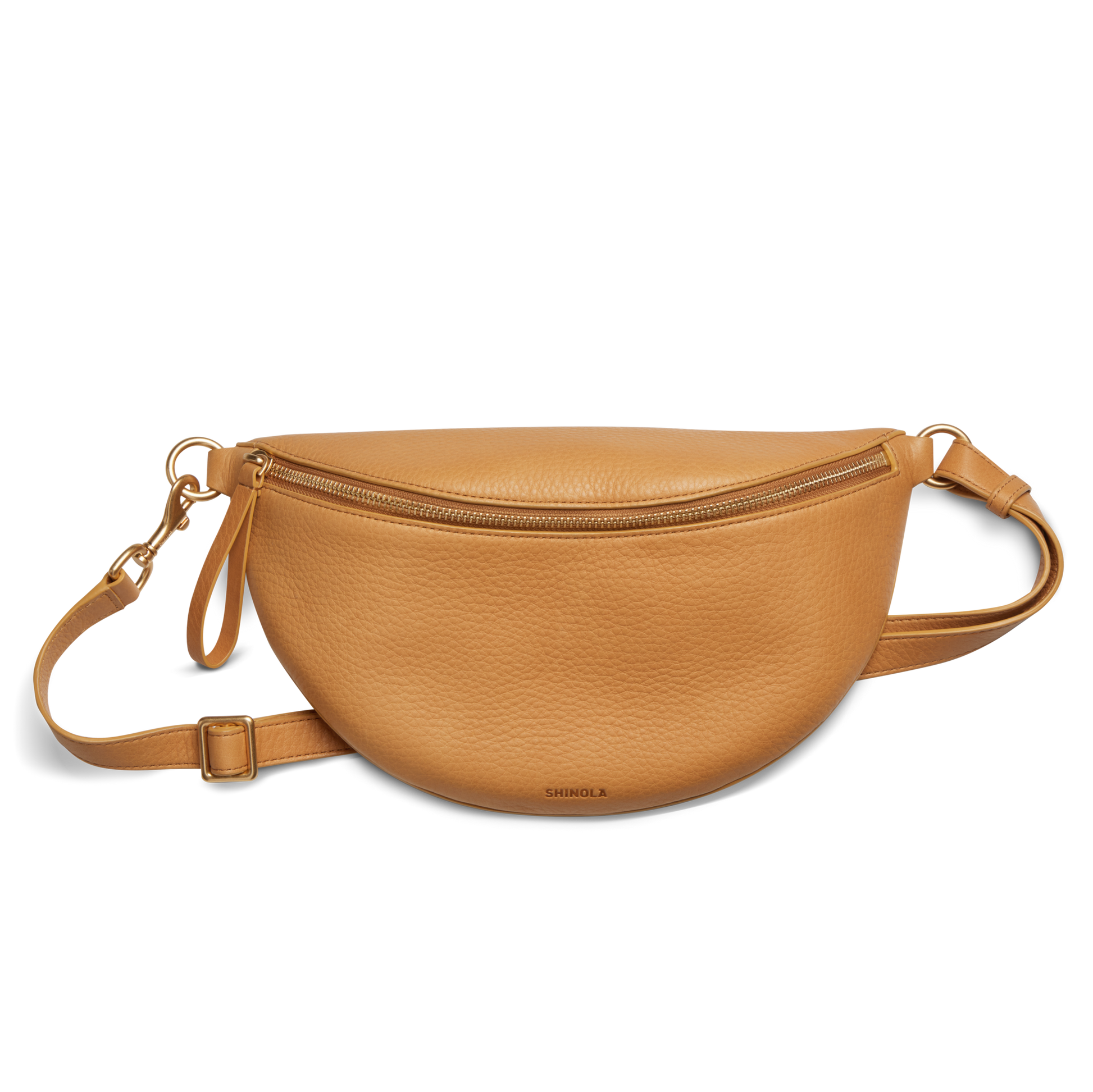 The Shinola Sling Bag - Honey, featuring a tan half-moon shape, zipper closure, adjustable leather strap, and gold-tone hardware, is shown against a white background.