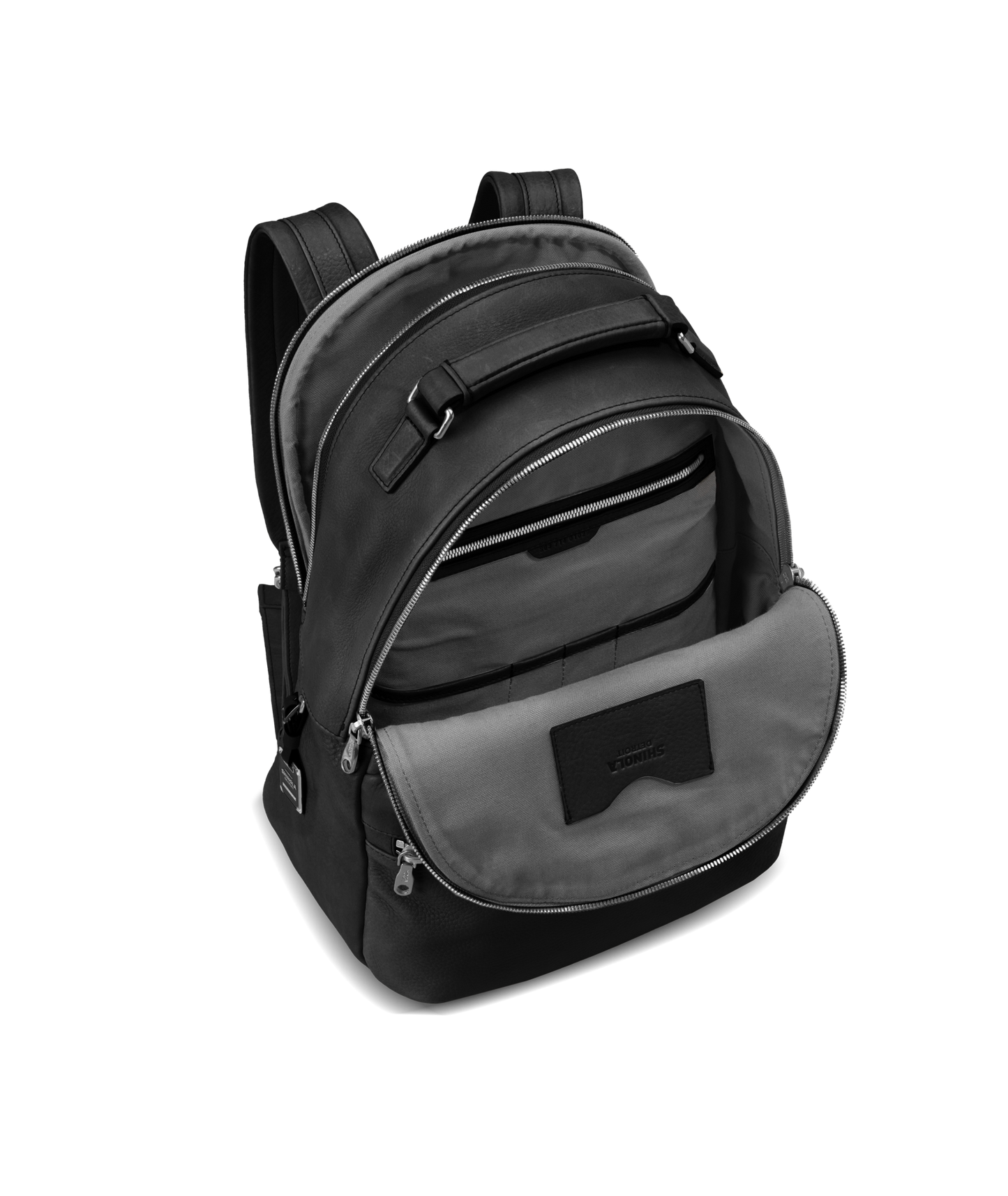 The Shinola Runwell Backpack - Black is shown with its main compartment open, revealing a gray lining, multiple interior pockets, padded shoulder straps, zipper closures, and a small front pocket. Crafted from premium black leather.