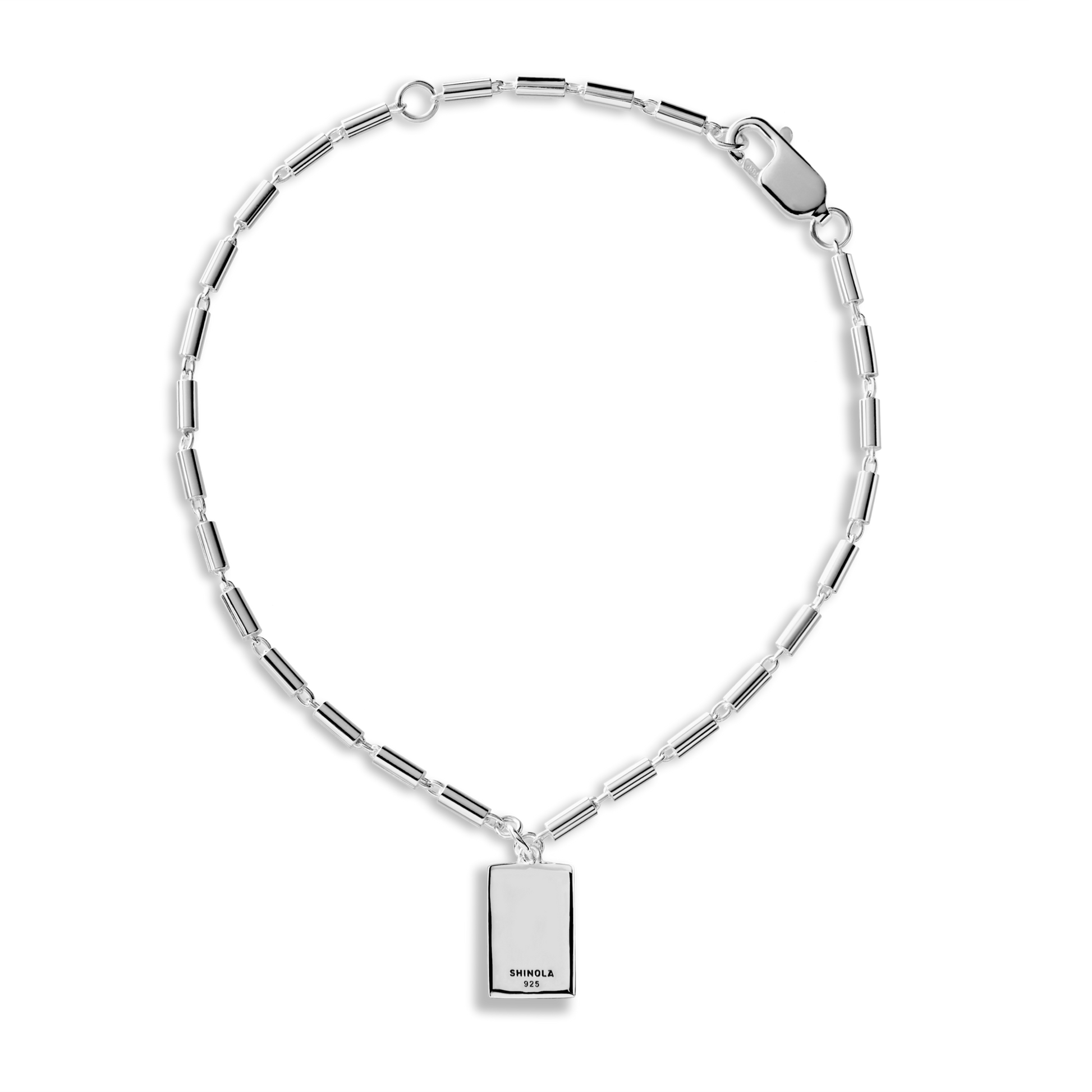The Petite Rectangular Tag Chain Bracelet by Shinola features elongated sterling silver links, a polished finish, a rectangular tag engraved with SHINOLA 925, and a secure lobster clasp. The tag is engravable for personalization.