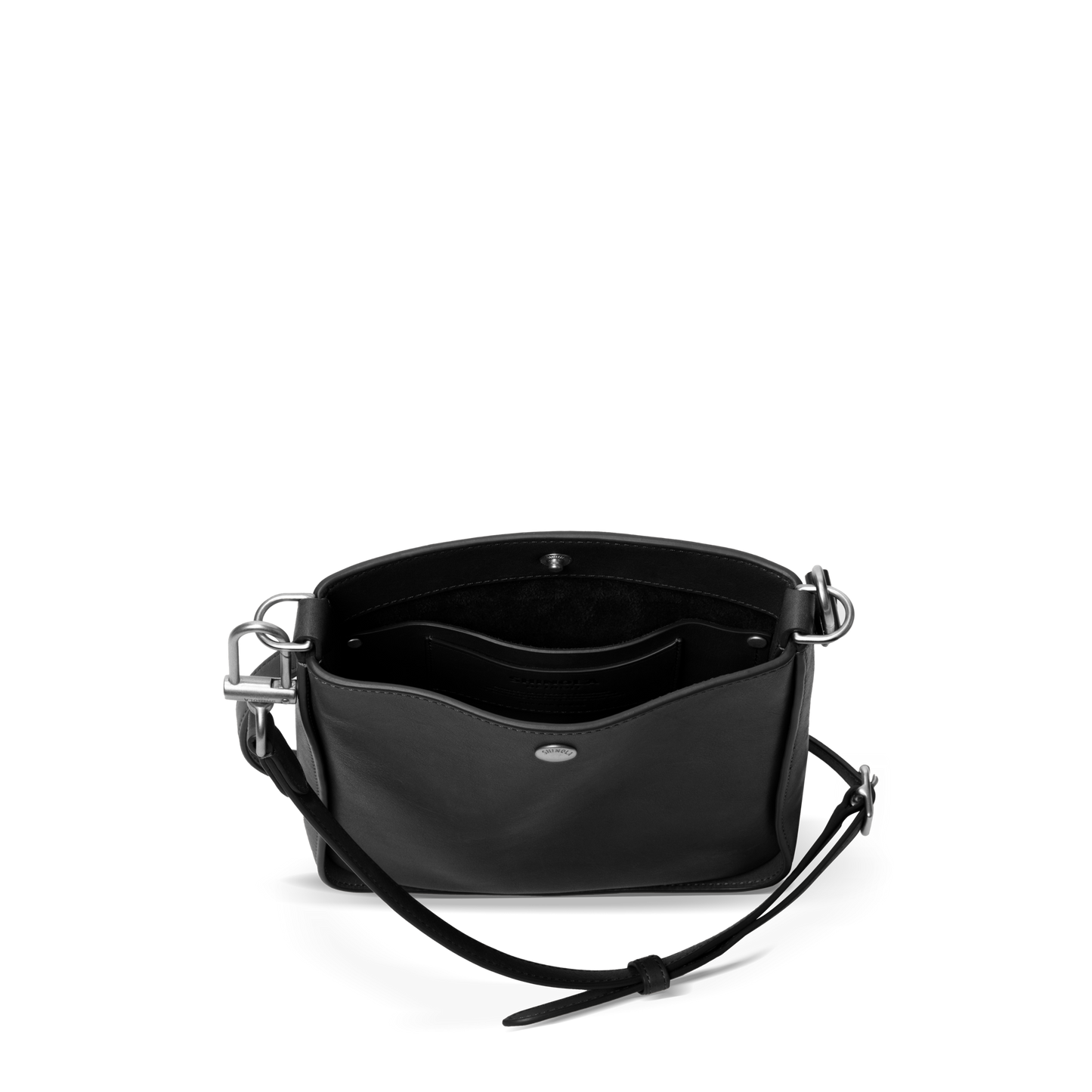 The Shinola Mini Pocket Crossbody Bag - Black, with silver hardware, is shown open against a white background displaying its roomy interior, two inner pockets, and an adjustable leather strap.