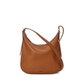 The Shinola Medium Bixby Crossbody - Tan features brown natural leather, a curved top, adjustable strap, and minimal design—versatile and perfectly displayed against a plain white background.