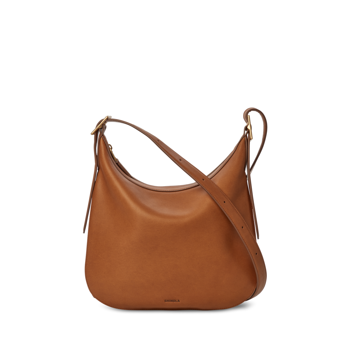 The Shinola Medium Bixby Crossbody - Tan features brown natural leather, a curved top, adjustable strap, and minimal design—versatile and perfectly displayed against a plain white background.