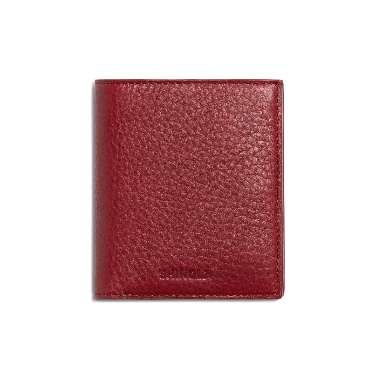 A closed Coin Bifold - Ruby wallet by Shinola, crafted from natural grain leather with a textured finish and embossed branding at the bottom, shown on a plain white background.