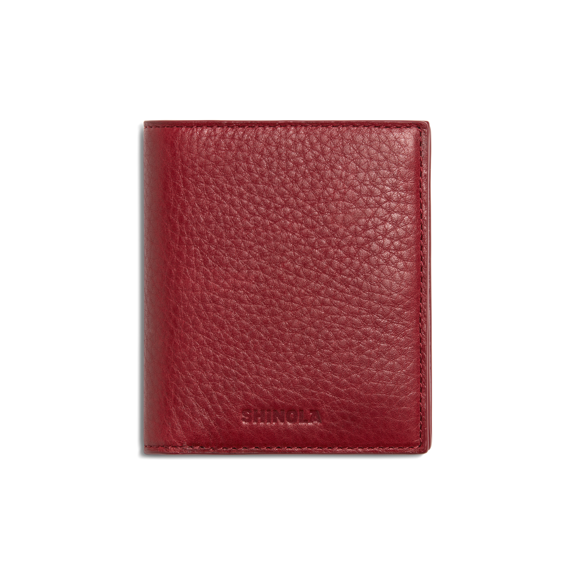A closed Coin Bifold - Ruby wallet by Shinola, crafted from natural grain leather with a textured finish and embossed branding at the bottom, shown on a plain white background.